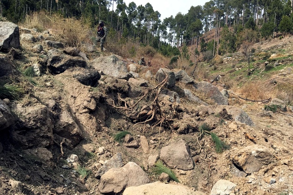 Pakistan army soldier walks near to the crater where Indian military aircrafts released payload in Jaba village, Balakot, Pakistan. PHOTO: ISPR