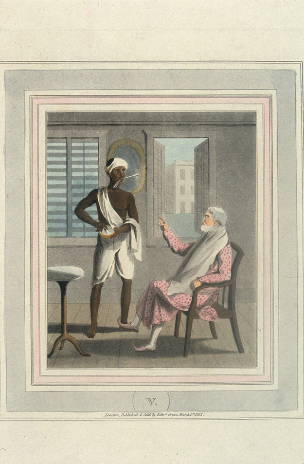 an indian servant holds a straight razor in his mouth while he prepares the shaving foam for his british master