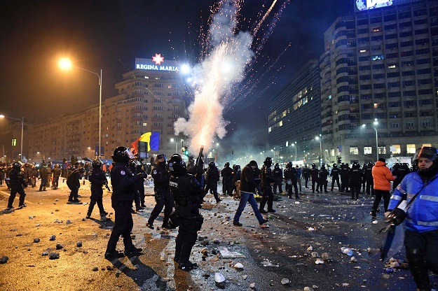 Romanian riot police  fire tear gas to disperse people taking part in a protest against controversial decrees to pardon corrupt politicians and decriminalize other offenses in front of the government headquarters in Bucharest, on February 1, 2017. PHOTO: AFP