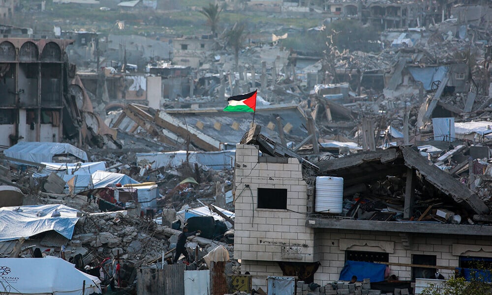 a palestinian flag flutters amid the ruins of buildings in beit lahia in northern gaza on march 4 2025 photo afp