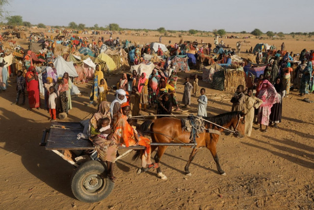 sudanese refugees who fled the violence in their country ride a cart as they pass other refugees standing beside makeshift shelters near the border between sudan and chad in koufroun chad may 6 2023 photo reuters sudanese refugees who fled the violence in their country ride a cart as they pass other refugees standing beside makeshift shelters near the border between sudan and chad in koufroun chad may 6 2023 photo reuters