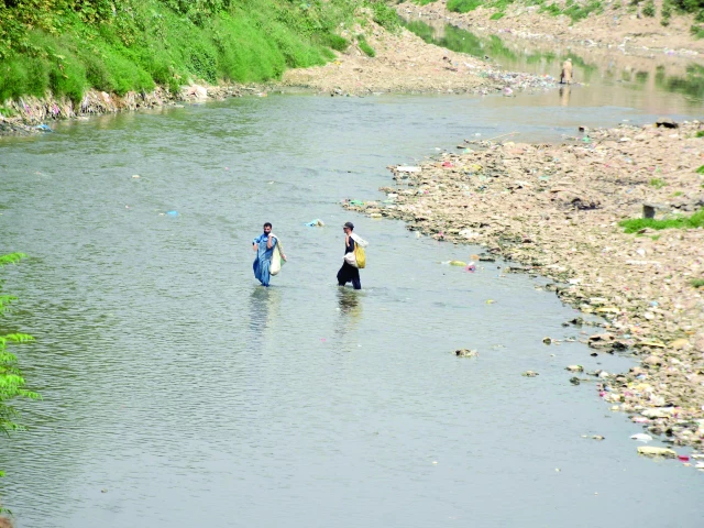 a destitute couple braves the polluted waters of nullah leh in rawalpindi searching for discarded items to salvage in dhok ratta rawalpindi photo agha mahroz express a destitute couple braves the polluted waters of nullah leh in rawalpindi searching for discarded items to salvage in dhok ratta rawalpindi photo agha mahroz express