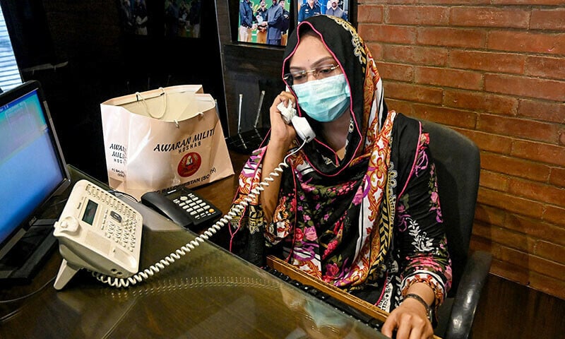 in this photograph taken on august 17 receptionist hina saleem talks on a telephone at a leather factory in karachi photo afp