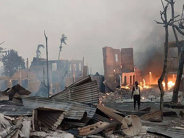 a man stands near a burning house at the site of a suspected air strike carried out by myanmar s military at kyauk ni maw village in western rakhine state photo afp