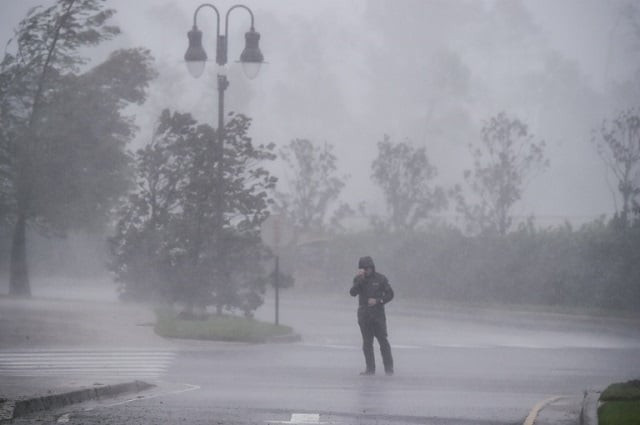 a reporter covers his face as while hurricane delta makes landfall in lake charles louisiana on october 9 2020 photo afp a reporter covers his face as while hurricane delta makes landfall in lake charles louisiana on october 9 2020 photo afp