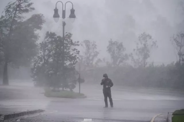 a reporter covers his face as while hurricane delta makes landfall in lake charles louisiana on october 9 2020 photo afp a reporter covers his face as while hurricane delta makes landfall in lake charles louisiana on october 9 2020 photo afp