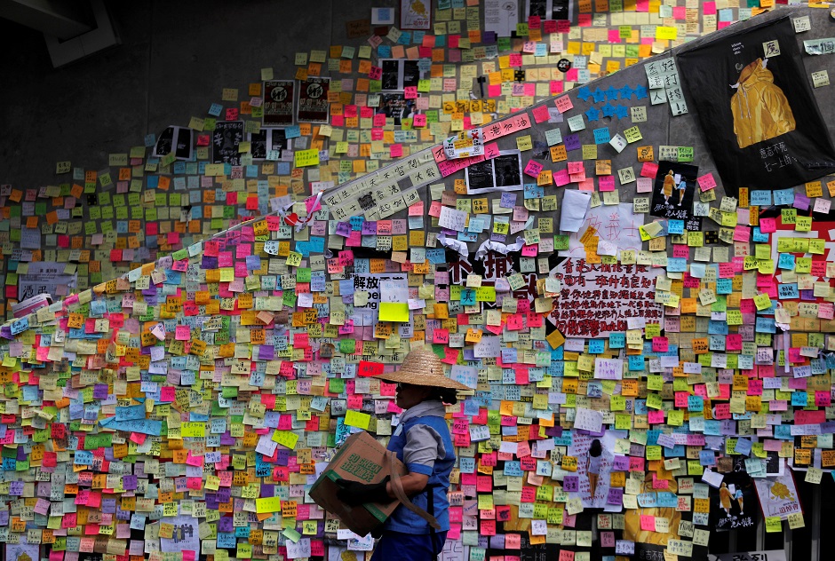 A worker walks past post-it notes scribbled with messages, left behind by protesters on the walls of the Legislative Council, in Hong Kong, China. Photo: REUTERS