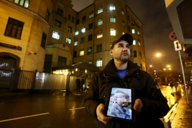 an activist holds a tablet with a picture of the lifeless body of a russian pilot of a war plane shot down by turkey in front of the turkish embassy in moscow russia november 24 2015 photo reuters an activist holds a tablet with a picture of the lifeless body of a russian pilot of a war plane shot down by turkey in front of the turkish embassy in moscow russia november 24 2015 photo reuters