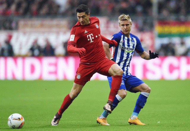robert lewandowski l and per cijan skjelbred r vie for the ball during the bundesliga football match fc bayern munich vs hertha berlin in munich on november 28 2015 photo afp