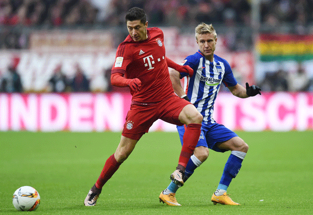 robert lewandowski l and per cijan skjelbred r vie for the ball during the bundesliga football match fc bayern munich vs hertha berlin in munich on november 28 2015 photo afp