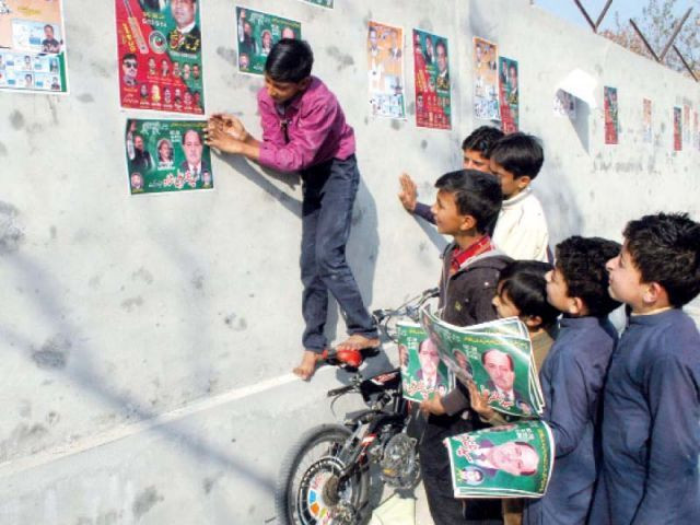 young boys move around the city finding empty walls on which to plaster stickers for various candidates photo waseem nazir express young boys move around the city finding empty walls on which to plaster stickers for various candidates photo waseem nazir express