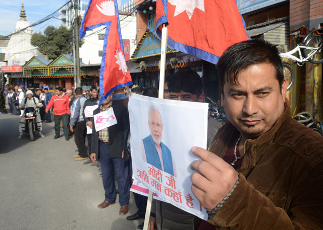 nepalese activists hold up placards bearing the image of indian prime minister narendra modi and join hands as they take part in a protest in kathmandu on november 30 2015 during an ongoing dispute between nepal and india photo afp