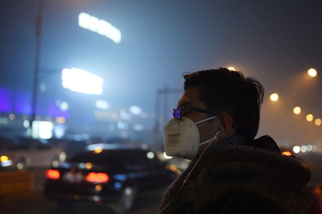 a man waits to cross a road on a heavily polluted evening in beijing on november 30 2015 photo afp a man waits to cross a road on a heavily polluted evening in beijing on november 30 2015 photo afp