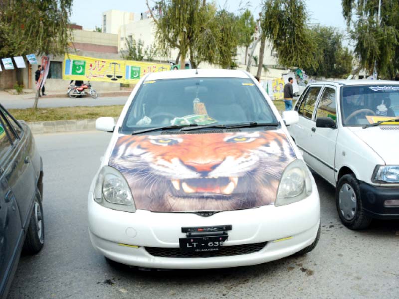 a vehicle decorated with pml n election symbol is parked outside a polling station photos mudassar raja huma choudhary express