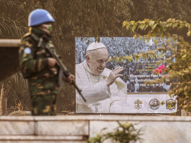 a united nations mission in central african republic soldier stands guard near a billboard announcing the visit of pope francis outside the barthelemy boganda stadium photo afp