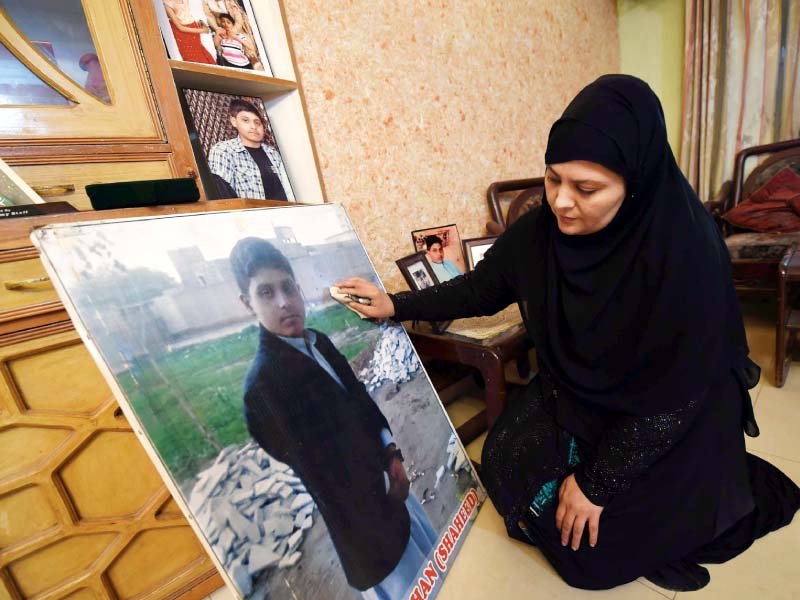 an aps attack victim s mother gazes at his photograph at her house in peshawar photo afp