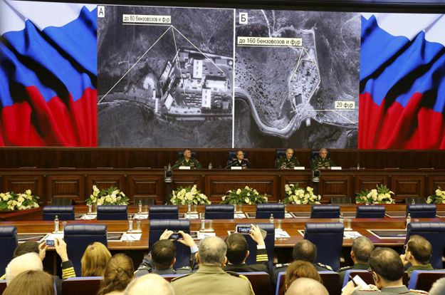 defence ministry officials sit under screens with satellite images on display during a briefing in moscow russia december 2 2015 photo reuters