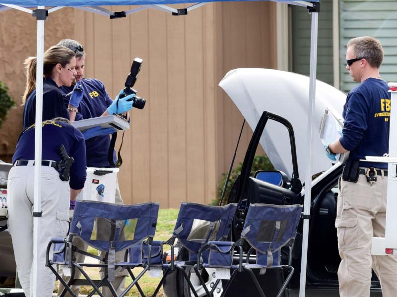 fbi agents examine a car outside a house in redlands california photo afp