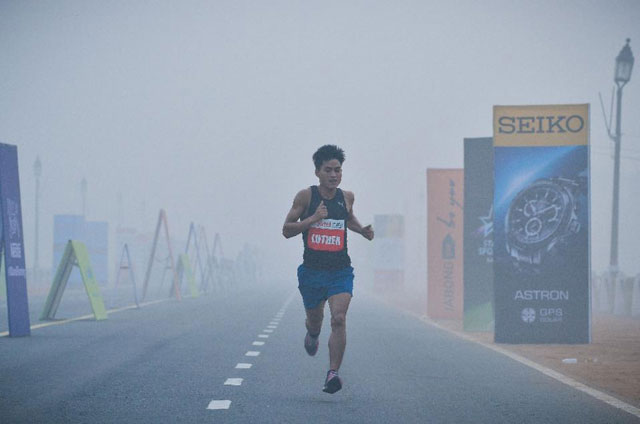 a participant runs through smog on rajpath during the airtel delhi half marathon 2015 in new delhi on november 29 2015 photo afp