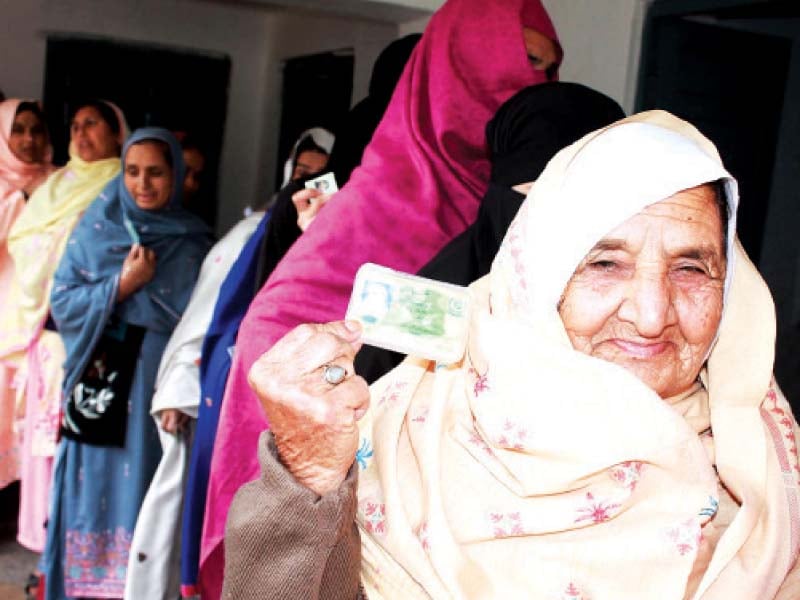 woman shows her identity card at a polling booth in sialkot photos online express