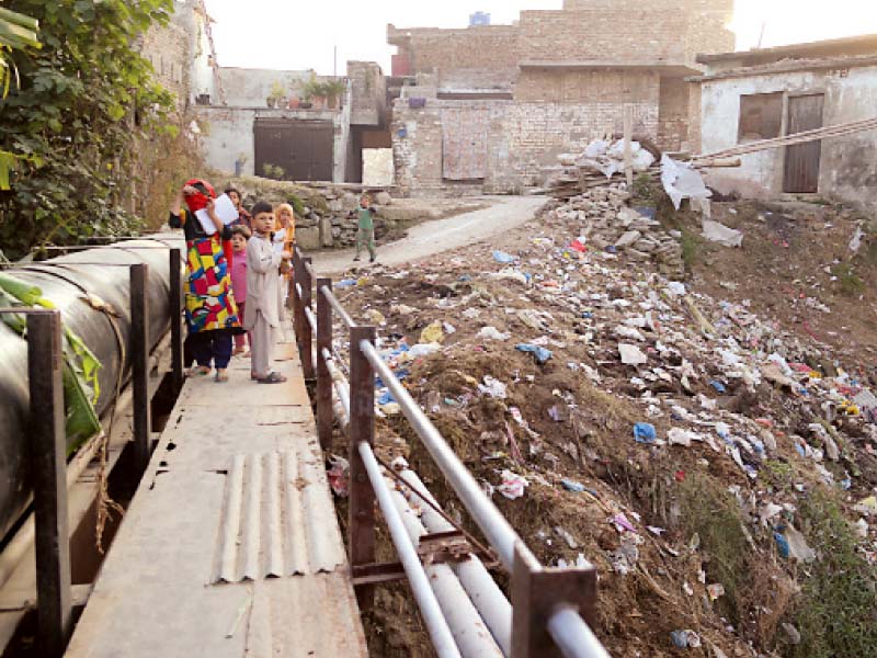 children residents stand outside their houses in the slum photo mariam shafqat express