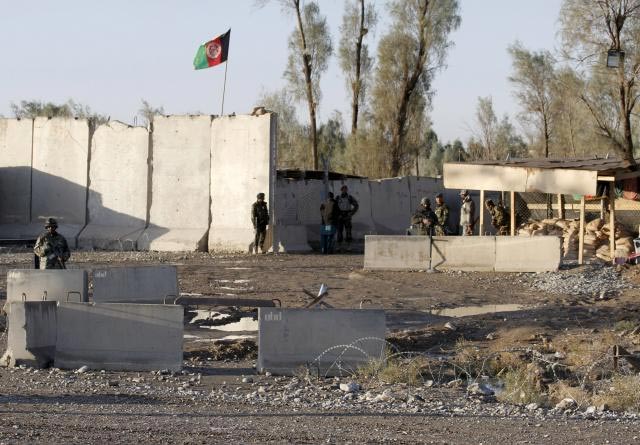 afghan security forces stand guard at the entrance gate of kandahar airport where taliban stormed on late tuesday in kandahar afghanistan december 9 2015