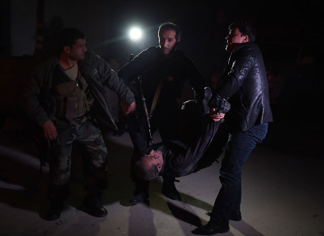 afghan security personnel carry a wounded man at the site of an attack near the spanish embassy compound in kabul on december 11 2015 photo afp