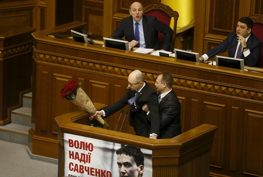 rada deputy oleg barna tries to remove prime minister arseny yatseniuk from the tribune after presenting him a bouquet of roses during the parliament session in kiev ukraine photo reuters