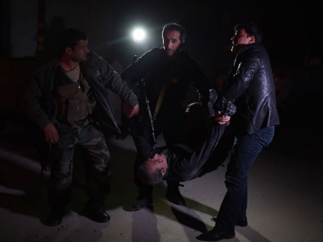 afghan security personnel carry a wounded man at the site of an attack near the spanish embassy compound in kabul on december 11 2015 photo afp