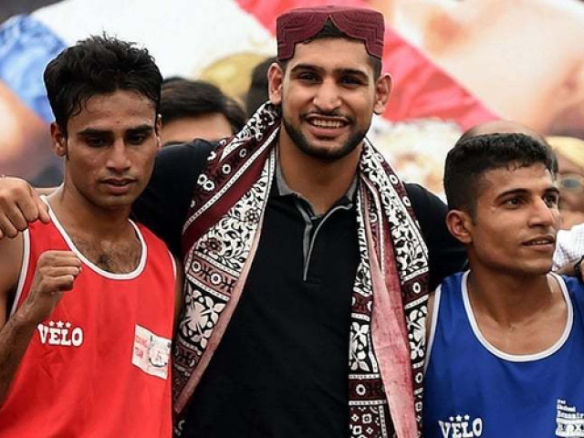 from the recent visit british boxer amir khan poses for a photograph with pakistani boxers jahan zaib and shahroz kachi in karachi lyari photo afp