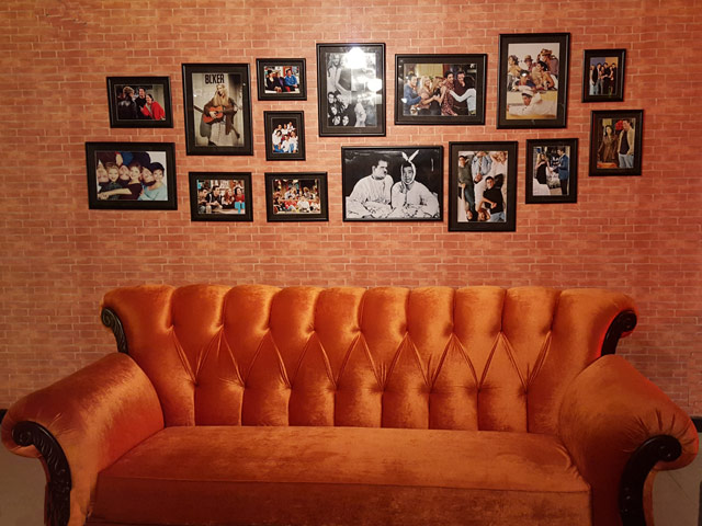the caf is fittingly filled with big orange couches with cast photos hung up on red brick walls photo ameena qayyum