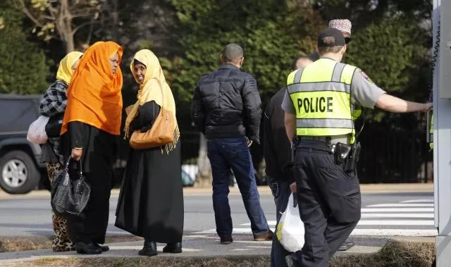 a fairfax county police officer controls traffic as women make their way to the dar al hijrah islamic center in falls church virginia just outside of washington