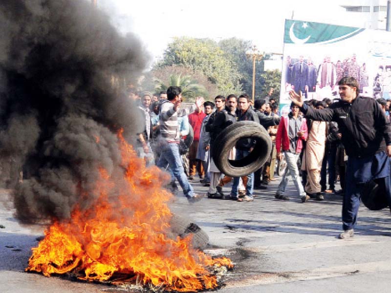 a protester throws a tyre on a bonfire at the demonstration on faisal chowk photo express