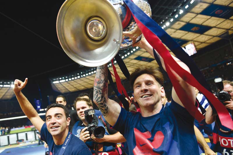 lionel messi celebrates with the champions league trophy after guiding his side to a historic treble at the olympic stadium in berlin photo afp