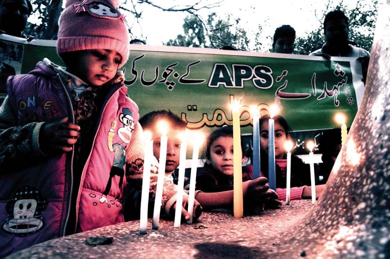 a child light candles on the first anniversary of aps carnage photo muhammad iqbal express