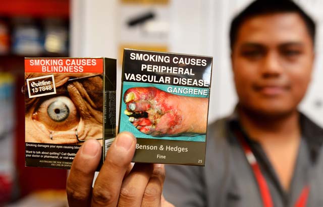 files a file photo taken on december 1 2012 shows bookshop supervisor sanjit amatya holding packaged cigarettes that have to be sold in identical olive brown packets bearing the same typeface and largely covered with graphic health warnings with the same style of writing so the only identifier of a brand will be the name on the package in sydney an australian law requiring cigarettes to be sold in plain packaging has received a boost after an international tribunal said it would not hear a tobacco company 039 s legal challenge australia was the first country to mandate plain packaging to reduce smoking rates in 2012 and has since been followed by other nations including france and britain photo afp