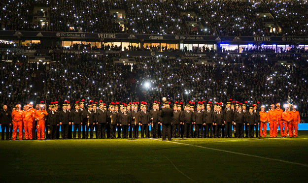 a choir of pitmen of shut down coal mine pit auguste victoria in marl sing on the pitch ahead of the german first division football match fc schalke 04 vs 1899 hoffenheim in gelsenkirchen western germany on december 18 2015 photo afp