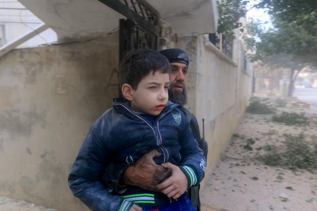 a rescue worker holds an injured boy after what activists said were airstrikes carried out by the russian air force in idlib city syria december 20 2015 photo reuters