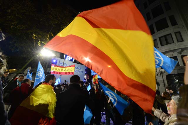 a popular party pp supporter holds a spanish flag in front of the party 039 s headquarters after the partial results of spain 039 s general election in madrid on december 20 2015 spaniards voted today in what is expected to be one of the most closely fought contests in the country 039 s modern history as two dynamic new parties take on long established political giants photo afp