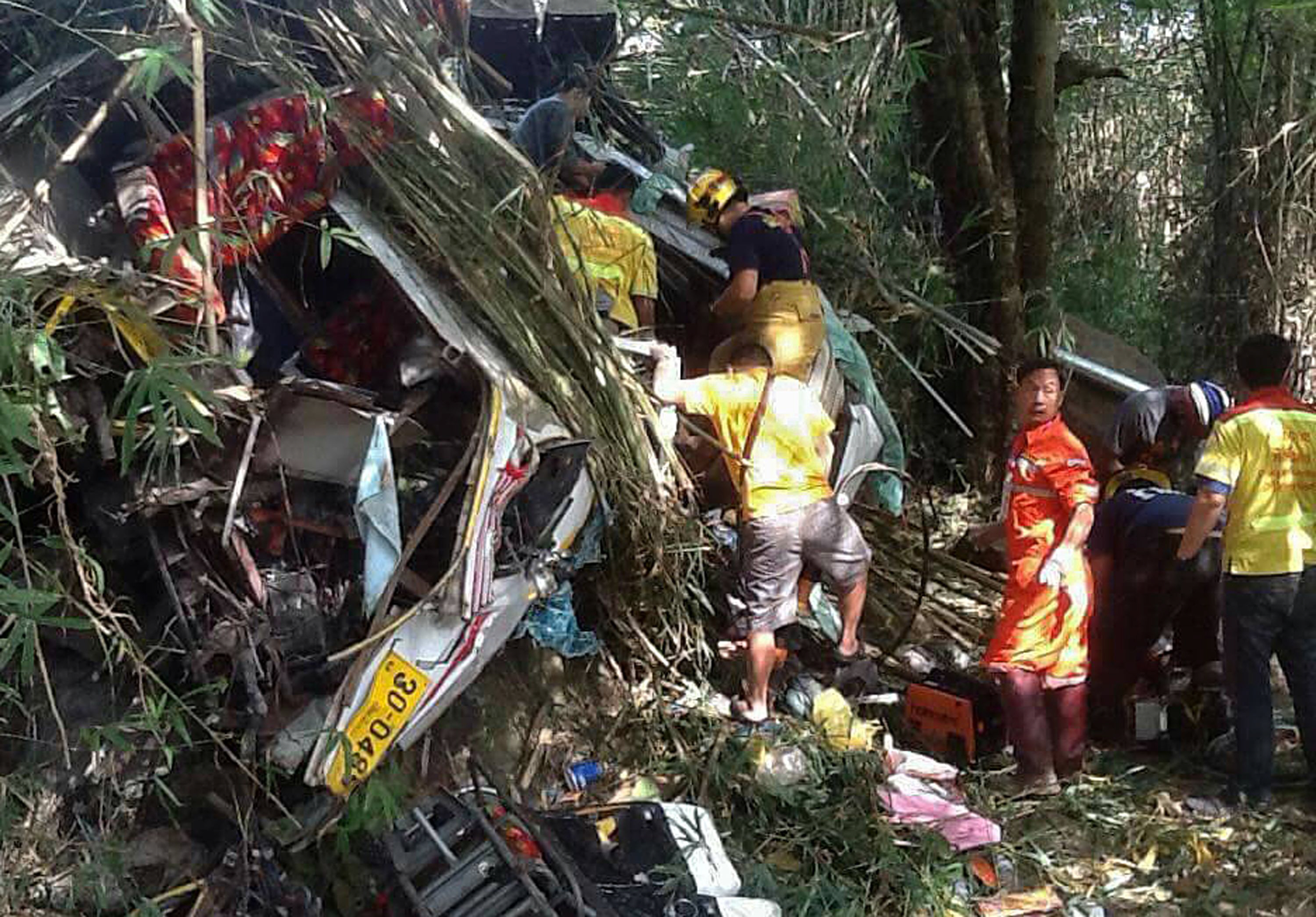 this photo taken on december 20 2015 shows thai rescue workers trying to find survivors following a bus crash in doi saket district 30 kilometres 18 miles from the northern city of chiang mai twelve malaysian tourists and a thai were killed in a bus crash in thailand a country with some of the world 039 s most dangerous roads according to information from police and a tour operator photo afp