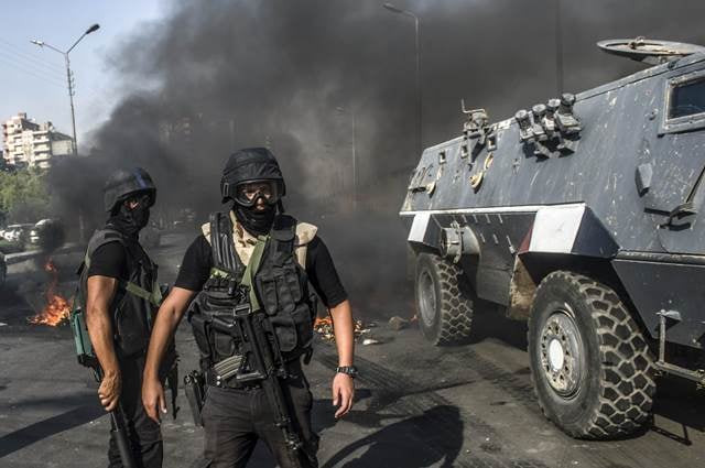 egyptian riot policemen secure a street near an armoured vehicle during a rally of supporters of the muslim brotherhood photo afp egyptian riot policemen secure a street near an armoured vehicle during a rally of supporters of the muslim brotherhood photo afp