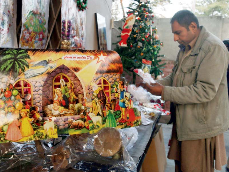 a worshiper purchases decoration items for christmas from a stall at st john s church in the city photo muhammad iqbal express