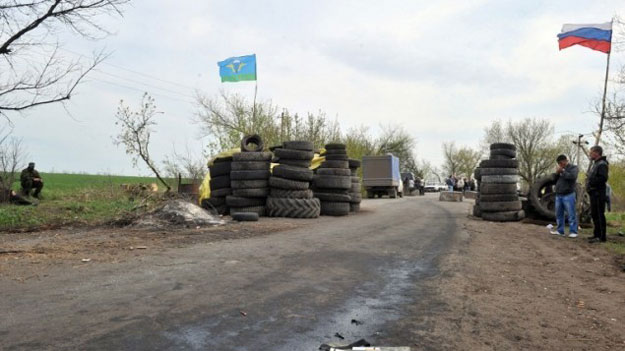 armed pro russian militants stand guard at a check point outside the eastern ukrainian city of slavyansk on april 20 2014 photo afp