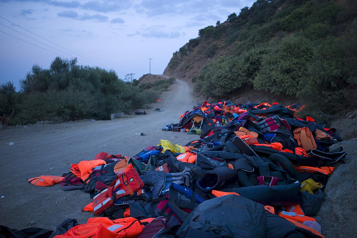 life jackets and deflated dinghies left behind by refugees and migrants are seen on the roadside near a beach on lesbos photo reuters