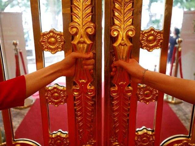 Staffers open the doors of the newly-inaugurated Dolce Hanoi Golden Lake luxury hotel, which features gold plated exteriors and interiors in Hanoi, Vietnam. Around a tonne of gold was used to cover the hotel, said Duong, a Vietnam War veteran and former cyclo taxi driver who made his fortune in construction and property. PHOTO: REUTERS