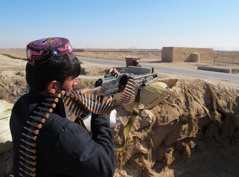 afghan police keep watch during an ongoing battle with taliban militants in the marjah district of helmand province on december 23 2015 photo afp