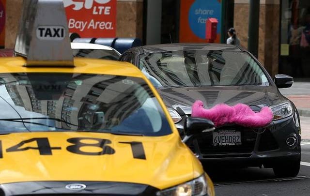 a san francisco taxi competes alongside a car run by lyft an uber like online cab service photo afp