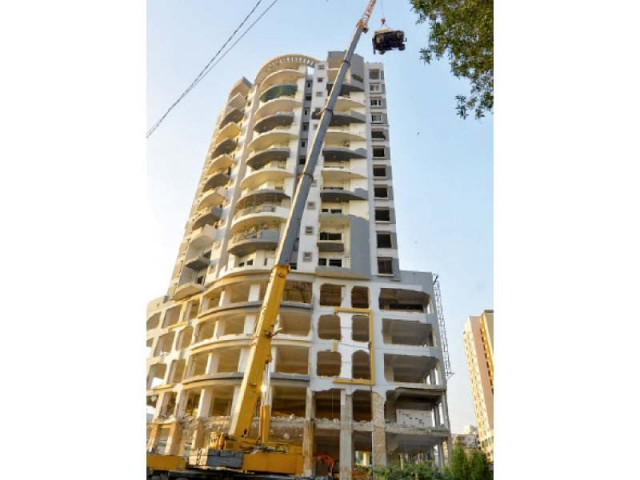 a snorkel lifts a shovel to the roof top of nasla tower for demolition of building photo express file a snorkel lifts a shovel to the roof top of nasla tower for demolition of building photo express file