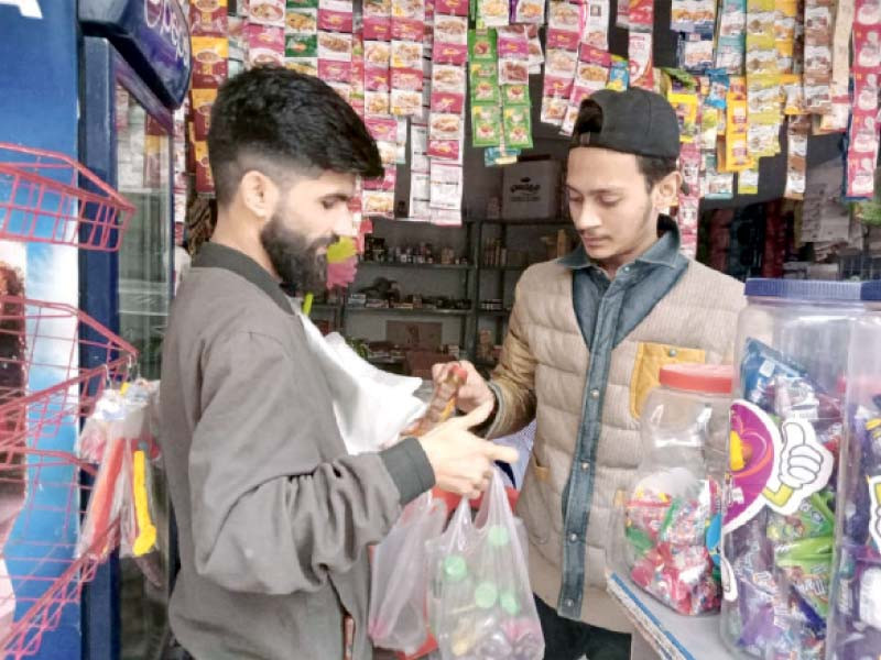 aftab ahmad khan alias pk niazi sells his inventory of plastic bags and hair oil bottles to a shopkeeper in liaquatabad photo express