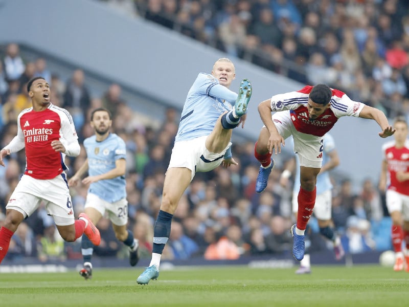 manchester city s erling haaland in action along with arsenal s william saliba during their premier league clash on sunday photo reuters